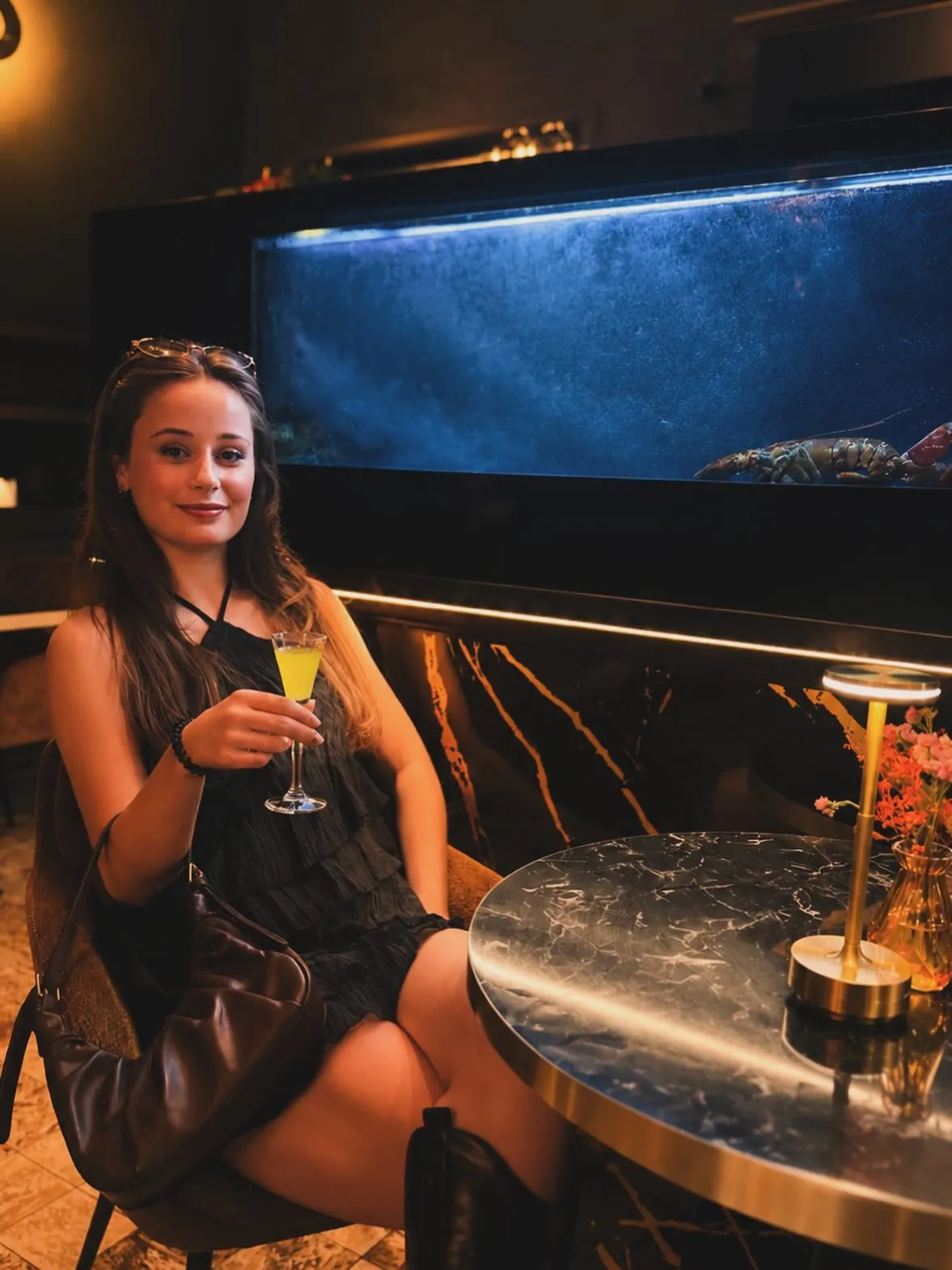 Gast met aperitief bij het kreeftenaquarium