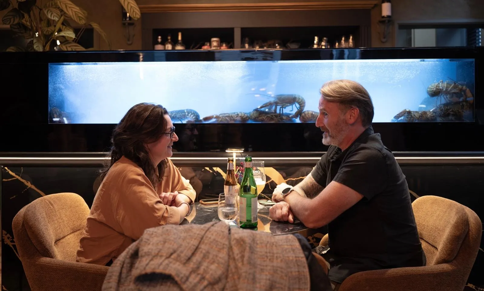 Koppel aan tafel bij het kreeftenaquarium