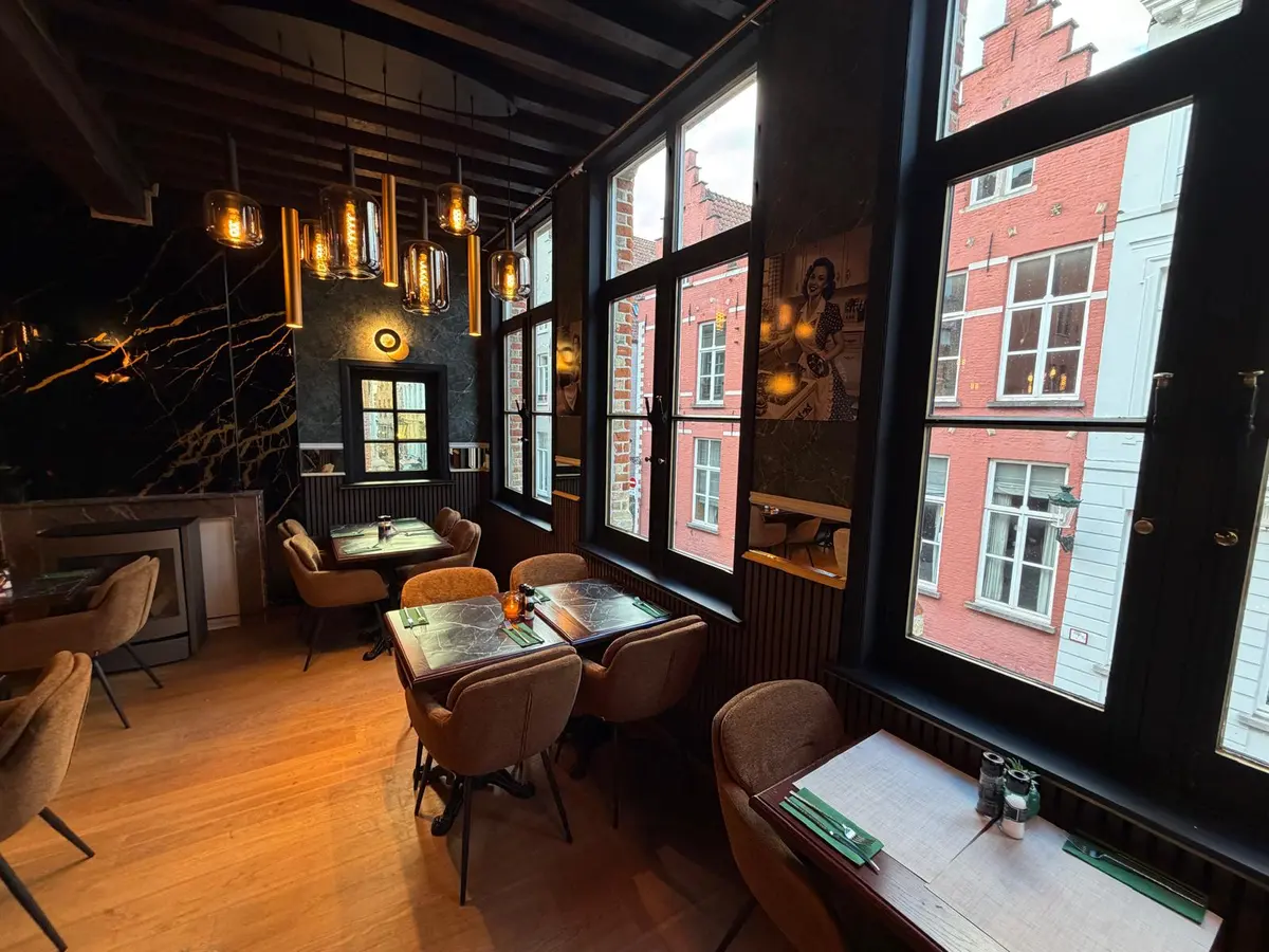 Tafels aan het raam met zicht op de trapgevels