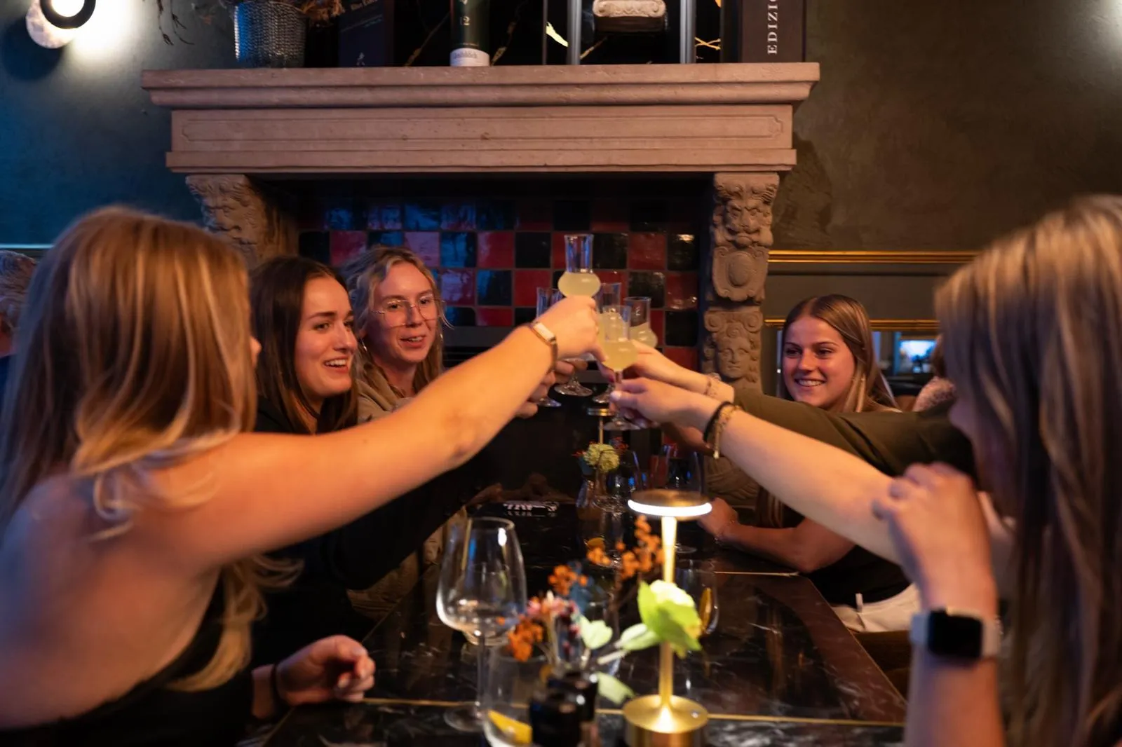 Vrienden klinken aan tafel bij Il Bosco
